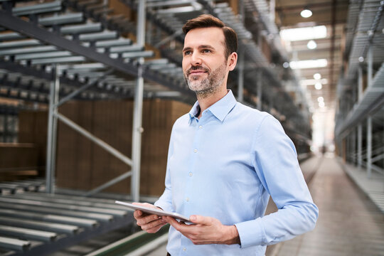 Confident businessman using tablet in a factory