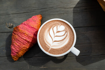 cup of cappuccino with fresh croissant