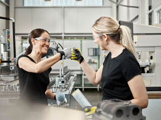 Two woman at work, fist bump