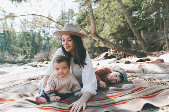 Mother and sons lying on blanket on the beach