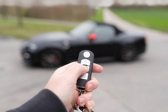 Hand With Key Opening Sports Car