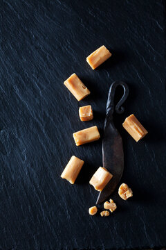 Cream toffees and old knife on black slate