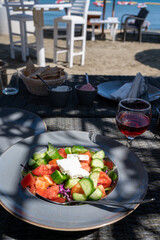 Summer healthy food served outdoor in sunlights, vegetable greek salad made with fresh cucumber, tomatoes, onion, feta cheese