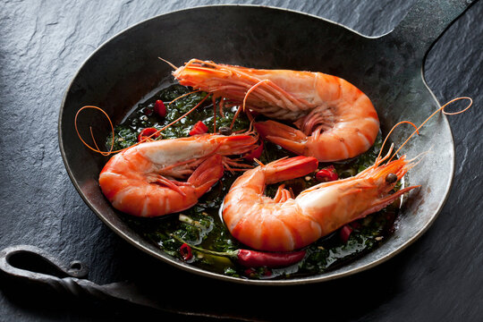 Prawns with hernbs, chili and garlic in iron pan