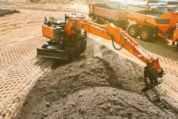 An excavator at a construction site plans the ground before work on the foundation