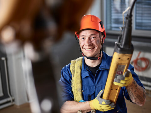Industrial worker using hand control of indoor crane