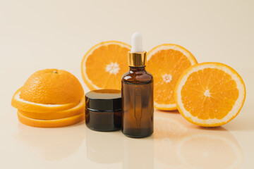 Vitamin C serum in cosmetic transparent bottle with dropper, sliced orange  close-up view. Facial skin care concept. Natural organic cosmetics beauty