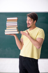 Young male student holding many books