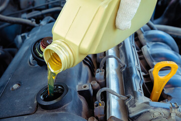 pouring engine oil into the engine