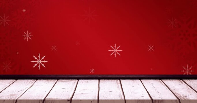 Animation of falling snowflakes on red background and wooden floor