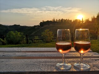 Two glasses of wine at sunset. Relaxing atmosphere, tasting of an excellent wine, admiring the spectacle of the sunset in good company.