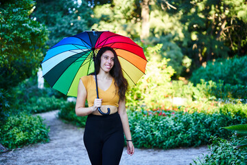 girl with rainbow umbrella walking in the park LGBT concept