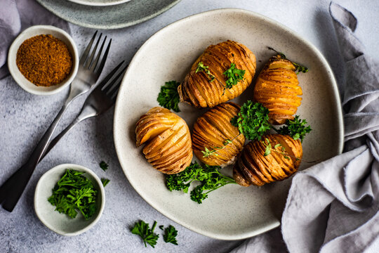 Bowl of hasselback potatoes with fresh parsley