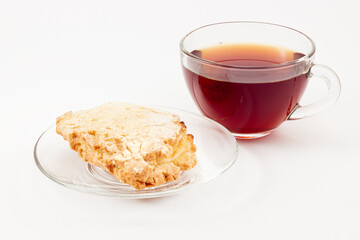 Sochen from shortcrust pastry with cottage cheese or curd and a cup of black tea isolated on white background. Russian pastries in the form of a flatbread folded in half with a half-open filling