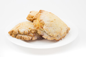 Sochen from shortcrust pastry with cottage cheese or curd in white plate isolated on white background. Russian pastries in the form of a flatbread folded in half with a half-open filling.