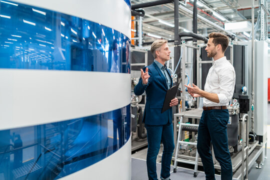 Two businessmen talking in a modern factory