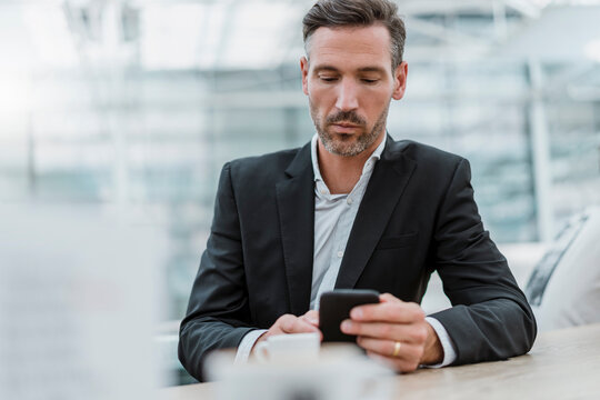 Businessman using cell phone in a cafe