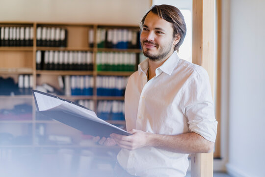 Bbusinessman with folder in wooden open-plan office