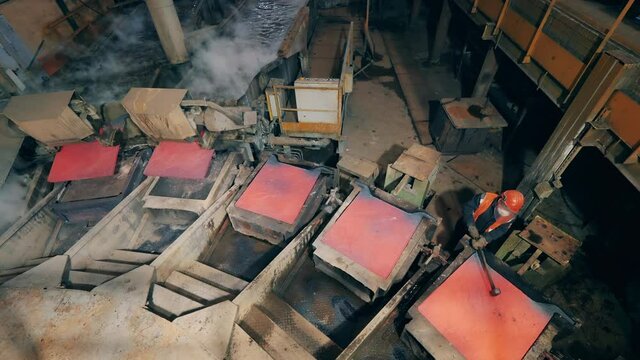 Metallurgist is hitting copper anode plates before casting