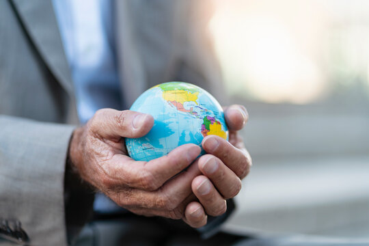 Close-up of hands of businessman holding globe