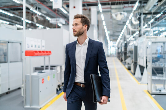 Businessman walking in a modern factory