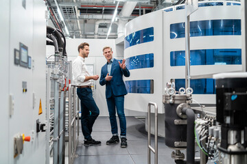 Two businessmen talking in a modern factory