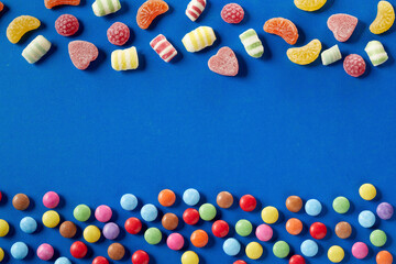 Colorful candies on bue background, copy space
