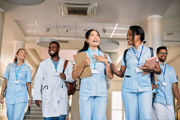 Happy multi-ethnic group of medical students have fun while talk in hallway at the university.