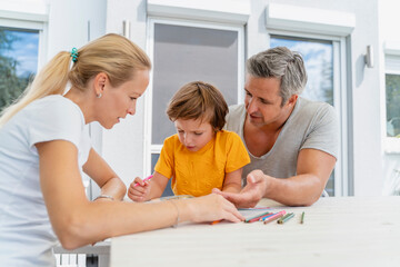 Father, mother and son doing homework together on terrace