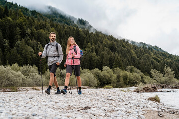 Young couple on a hiking trip at riverside, Vorderriss, Bavaria, Germany