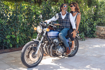 Fototapeta na wymiar Happy mature couple on a vintage motorbike