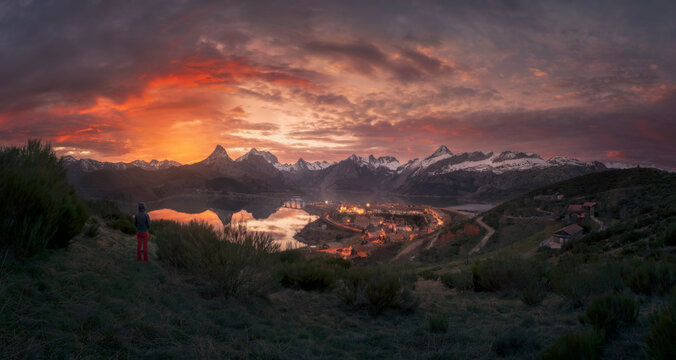 Hiker looking to Riano Lake and mountains at sunset,  Leon, Spain