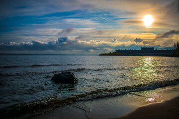 Sandy beach with boulders on the background of the rising sun