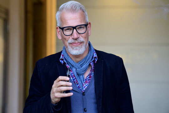 Portrait of a mature man, smoking electronic cigarette