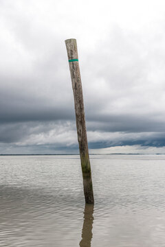 Germany, Nessmersiel, wooden stake in the sea
