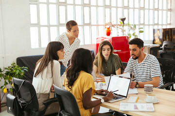 Colleagues working together at desk in office
