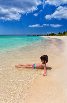 Shirtless girl playing on sea shore at beach during summer vacation, Punta Sur, Cozumel, Mexico