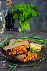 Delicious burritos with beef and vegetables wrapped in dark pita bread. Grilled mexican burrito