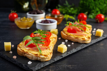 Grilled bruschetta with chicken rillettes, jamon and herbs. Delicious toast with chicken pate and different appetizers