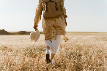 Rear view of female traveller with backpack on meadow