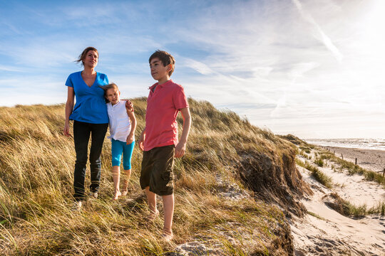 Mother with two children in a beach dune at the sea, Darss, Mecklenburg-Western Pomerania, Germany