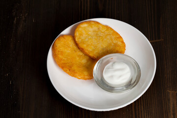 potato pancakes with sour cream on a plate