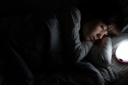 Girl sleeping in bed at night with night light