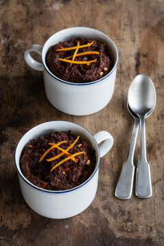 Mugs of gluten and lactose free chocolate puddings with canihua, chili and orange