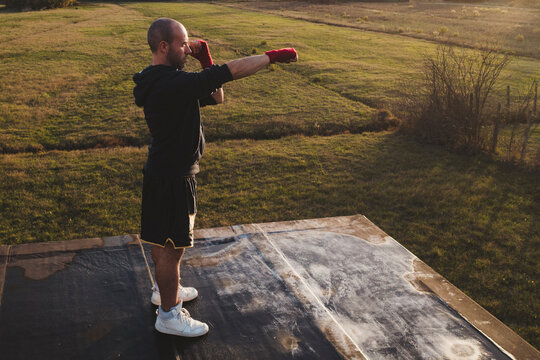 Boxer standing on platform in fighting pose outdoors