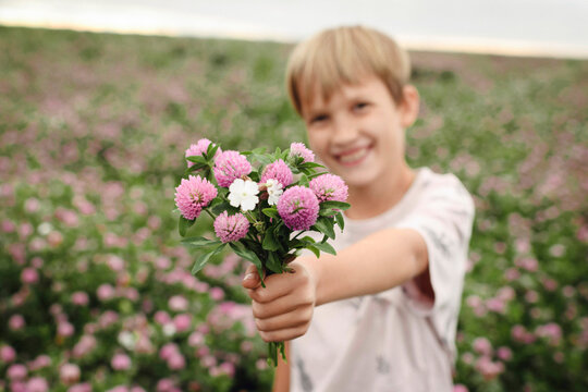 Smiling boy giving clover flowers