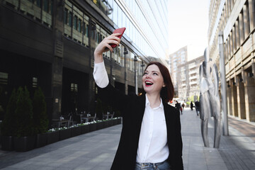 Stylish woman taking selfies in the city