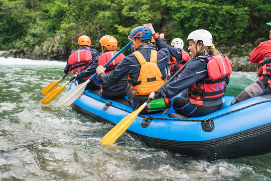 Group of people rafting in rubber dinghy on a river