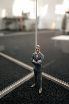 Businessman figurine standing between glass panes