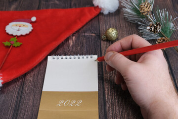 Male hands close-up. A man writes a letter to Santa Claus. Concept for Christmas, New Year 2022.
